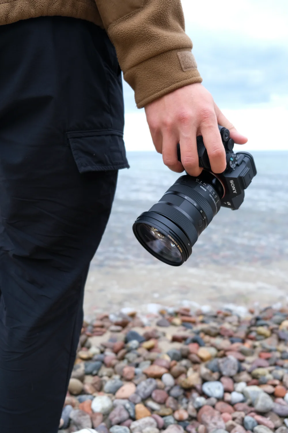 Marumi PRIME II Lens Protect – ochrona obiektywu w nowym wydaniu zdjęcie przedstawiające aparat z obiektywem w dłoni fotografa z widocznym filtrem PRIME II LENS PROTECT